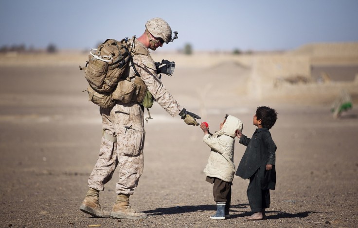 soldier-giving-red-fruit-on-2-children-during-daytime-36785